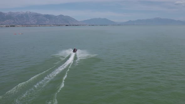 Jet Ski Sea Doo Rider on Lake with Beautiful Mountainous Background, Aerial