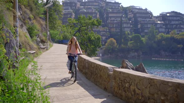 Slowmotion Shot of a Young Woman That Rides a Bicycle in the City of Budva a Famous Tourist Place in