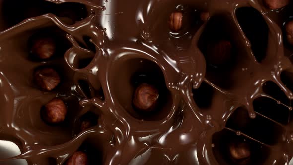 Super Slow Motion Shot of Hazelnuts Falling Into Melted Chocolate at 1000 Fps