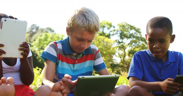 Group of kids using mobile phone and digital tablet