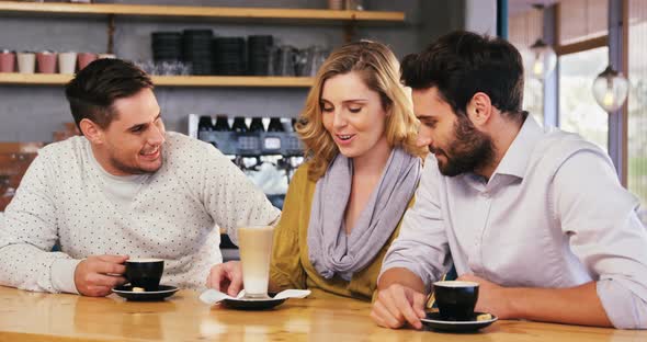 Friends interacting while have a cup of coffee