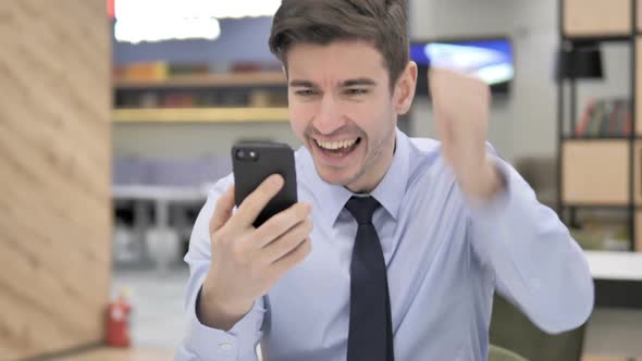 Excited Successful Businessman Using Smartphone