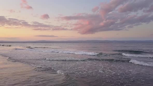 Aerial View of a Sea Surface with Blue Water Waves Under Sunset Sky