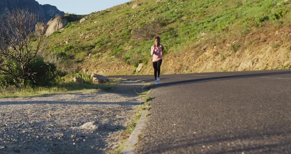 African american woman exercising outdoors running in country side during sunset