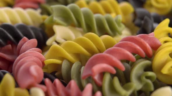 Multicolored raw Italian fusilli pasta falling into a heap in slow motion