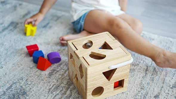 Cute Caucasian Little Girl Playing on the Floor at Home with Eco Wooden Toys