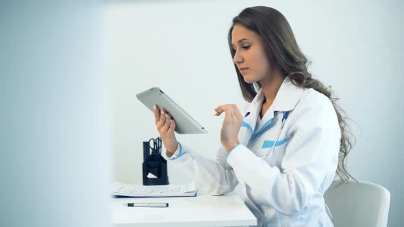 Female Doctor Using Tablet Computer in Medical Office