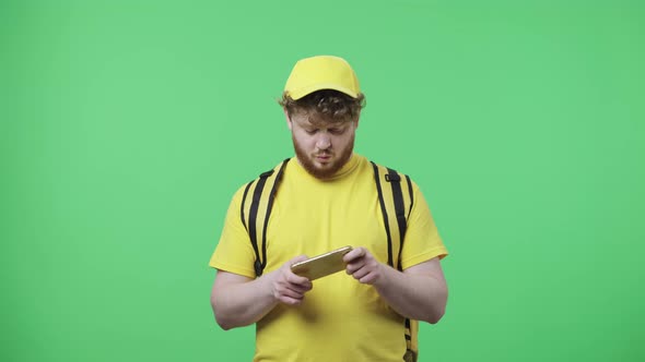 Portrait of Young Men Playing Game on His Phone and Rejoicing in Victory