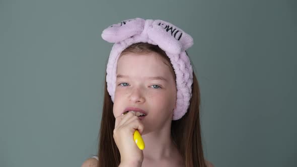 Little Cute Girl Brushing Her Teeth with a Toothbrush