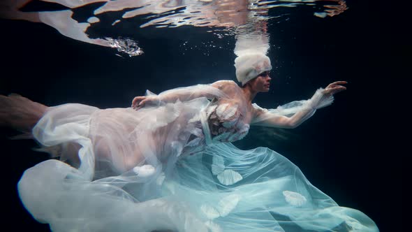 Beautiful Woman is Swimming Underwater Slow Motion Shot in Depth of Sea or Ocean