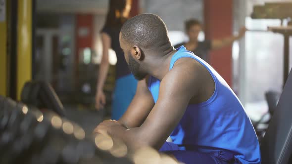 Handsome Self-Confident Man Looking at Ladies in Gym, Smiling and Flirting