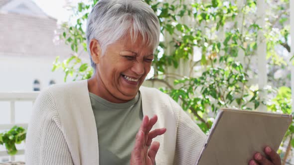 Senior mixed race woman having video chat using tablet in garden