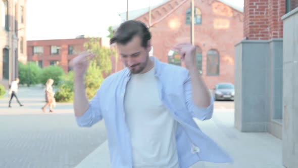 Man Dancing in Joy While Walking in Street