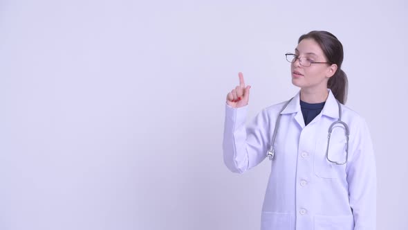 Happy Young Beautiful Woman Doctor Thinking and Pointing Up