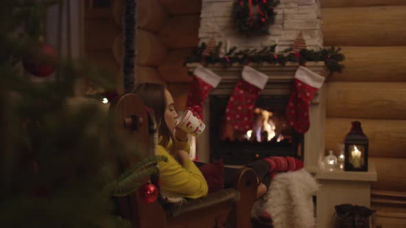 Woman relaxing by the fire in a chalet