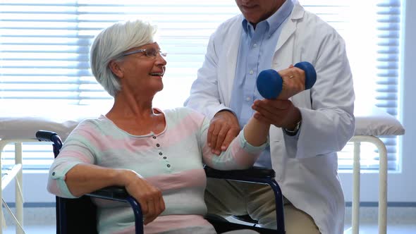 Physiotherapist assisting senior patient with hand exercise