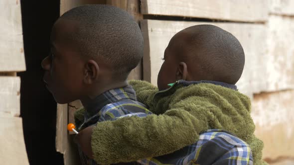 African child carrying another child on his back