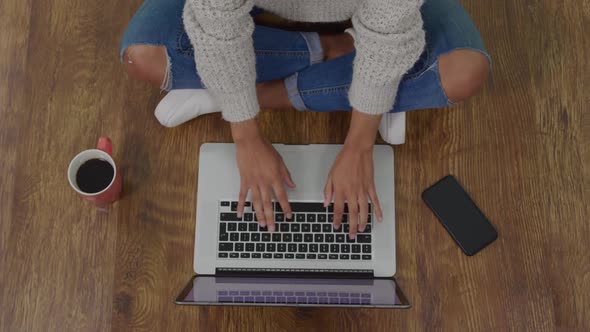 Woman using laptop and drinking coffee