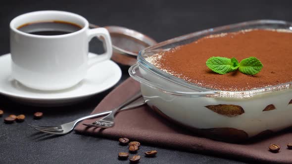 Tiramisu Dessert in Glass Baking Dish and Cup of Espresso Coffee on Concrete Background