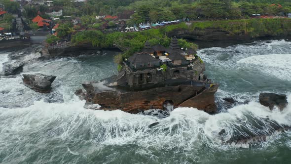 Overhead Aerial Rotating View of Stunning Buildings in Tanah Lot Temple on a Dark Ocean Cliff in