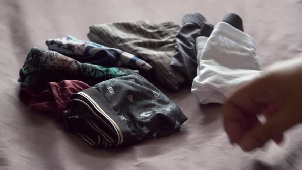 Men use their hands to fold men's underwear to keep it organized and easy to store and use. 4K, 29.9