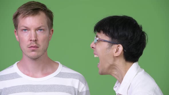 Young Angry Asian Businessman Screaming at Young Scandinavian Businessman