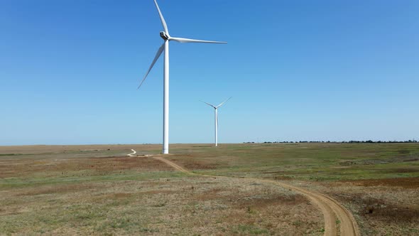 Working Wind Turbines Standing on the Field in Summer