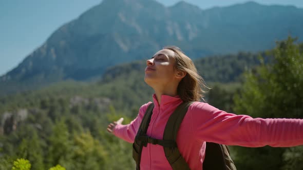 Slow Motion Closeup Portrait of Beautiful Young Woman Hiker Standing on Beautiful Mountain Landscape