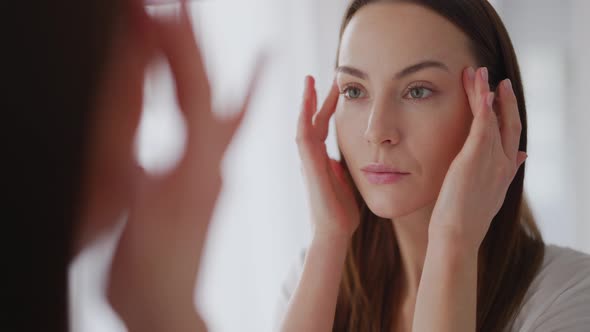 Woman Examining Perfect Skin Near Mirror