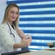 Smiling Nurse Taking Selfies with Her Phone Behind Reception Desk - VideoHive Item for Sale