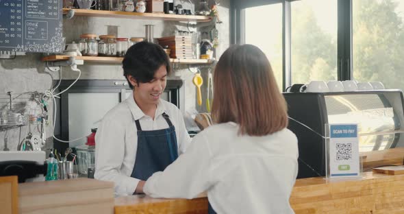 woman and man barista talking together during working at the counter at the cafe coffee shop