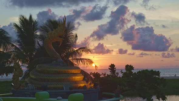 Scenery Sunset In Front Of The Naga Statue At Karon Beach, Phuket.