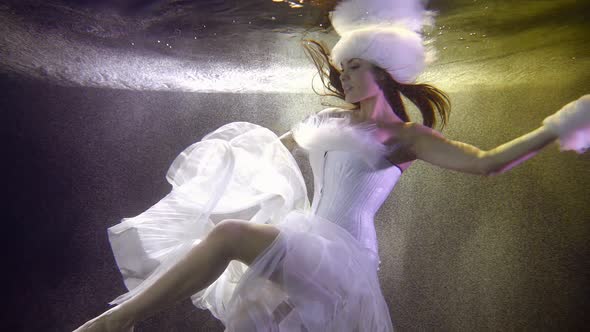 Snow Maiden with Chiffon Skirt Swims Underwater Slow Motion