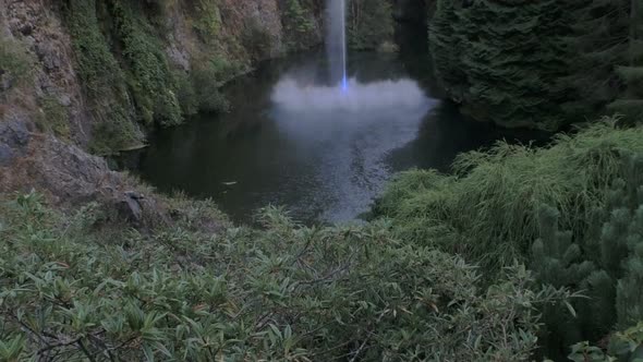 A single stream of water shoots from a secluded lake.