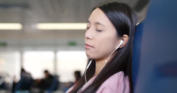 Woman sleeping on ferry and listen to music