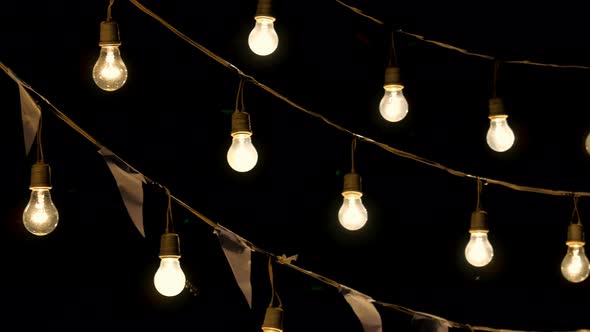 Light bulbs garland hanging in the air, Pan shot.