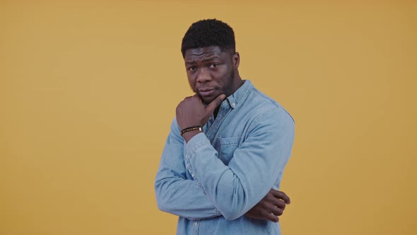 Attractive Pensive Confident African American Man Looking at Camera Wearing a Denim Shirt Rubbing