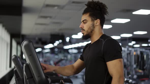 Fitness Man Starting His Training Cardio Exercise on Running Machine in Gym