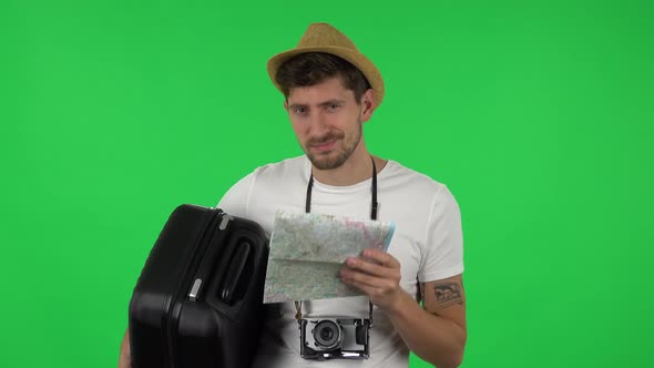 Portrait of Tourist with Suitcase in Hand, Retrocamera and Map Is Looking at Camera with Seductive