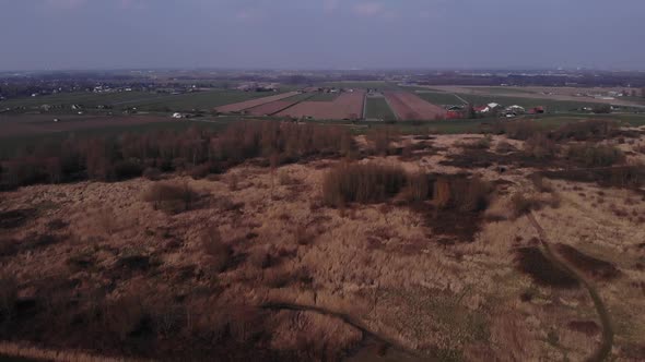 Panorama Of Countryside Landscape With Agricultural Fields Along Road And Town In Background During