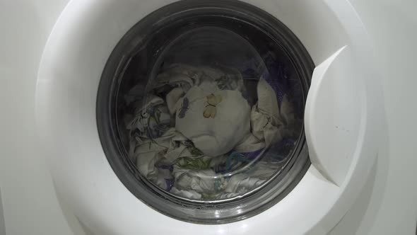 White Washing Machine Washes Dirty Colorful Clothes