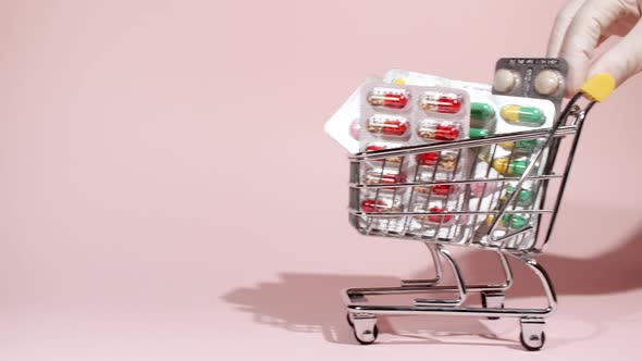 Closeup of Different Medical Pills in the Basket on Pink Background