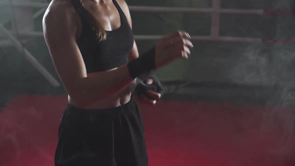 Female Fighter Wraps Her Hands with Boxing Bandages, Kickboxing Training Day in a Gym, Neon Lighting