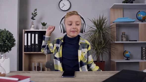 Teen Blond Cheerful Boy in Stylish Shirt which Dancing Under Modern Music in His Headphones