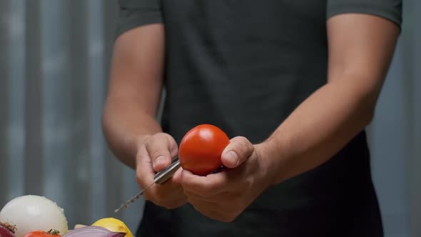 The Chef Cuts the Tomato While Holding It