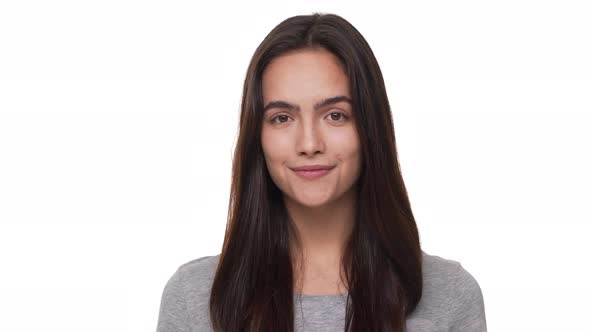 Portrait of Happy Female Model with Long Dark Hair Looking at Camera Smiling Positively Nodding