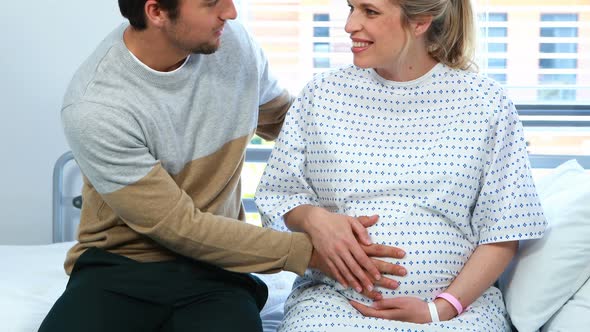 Man interacting with pregnant woman in ward