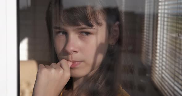 Teen Looking Out the Window