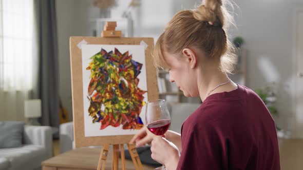 Young Woman Artist Draws a Picture with Oil Paints at Home in the Living Room