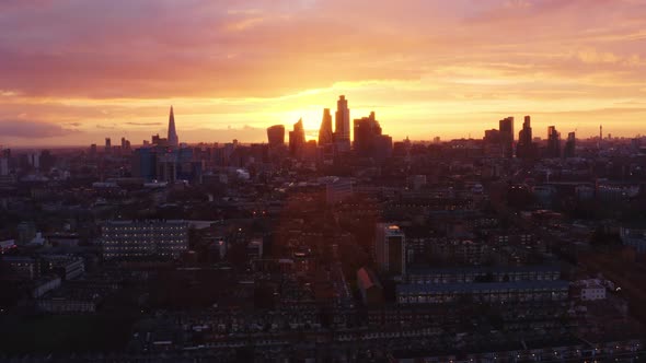 Long dolly forward Aerial drone shot of beautiful sunset behind City of London skyscrapers